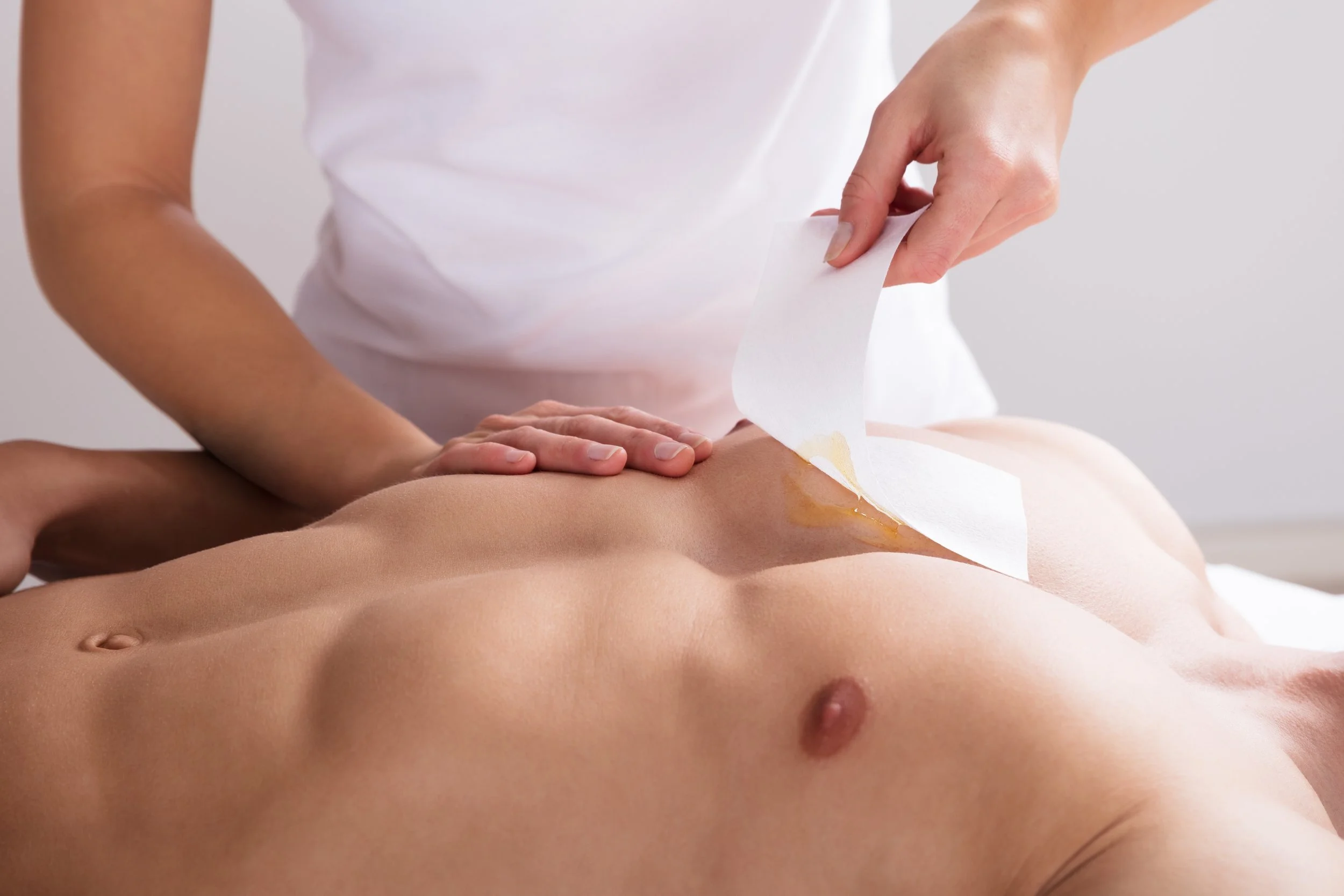 Woman Waxing Man's Chest With Wax Strip electrolysis melbourne